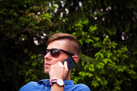 person holding Android smartphone wearing black sunglasses photo