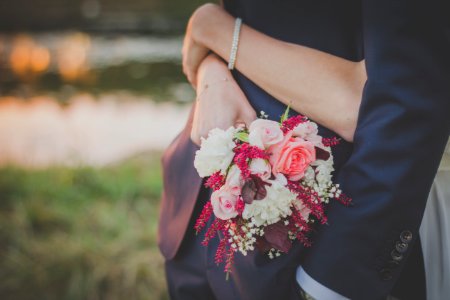 woman holding flower bouquet while hugging man photo