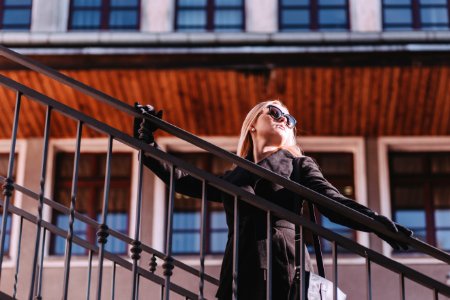 woman standing on stair while holding rails during daytime photo