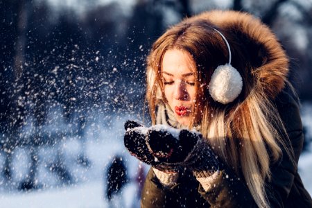 woman blowing snow on her hands photo