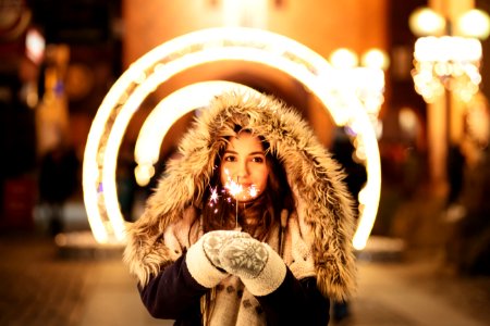 woman wearing coat and holding fireworks photo