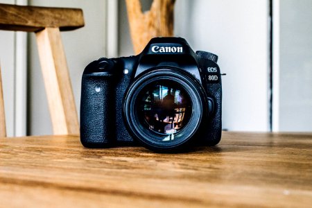 Canon DSLR camera on brown wooden table during daytime photo