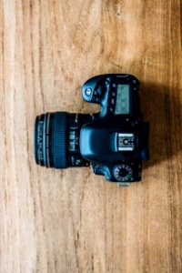 black dslr camera on brown wooden table photo