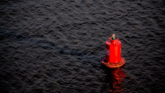 red buoy on body of water photo