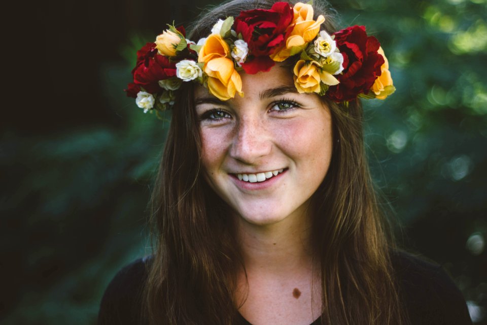 selective focus photography of smiling woman wearing floral headdress
