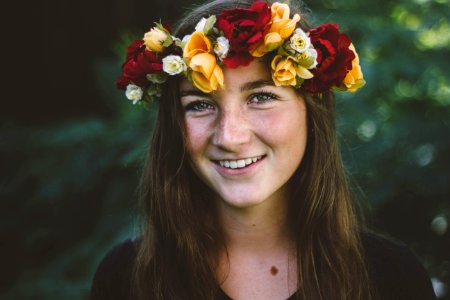selective focus photography of smiling woman wearing floral headdress photo