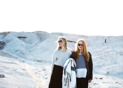 two women standing on snow covered surface photo