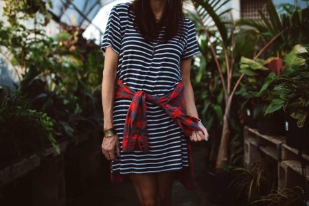 woman wearing black and white striped dress standing in isle near green plants photo