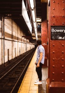 man standing beside subway platform photo