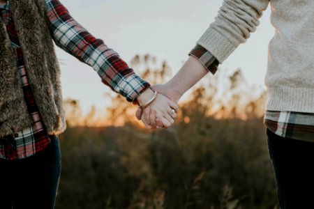 two person holding hands while standing photo