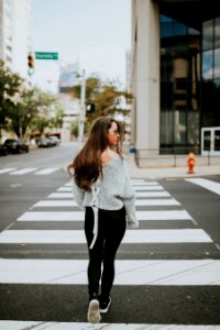 woman looking towards her right while walking along pedestrian lane during daytime