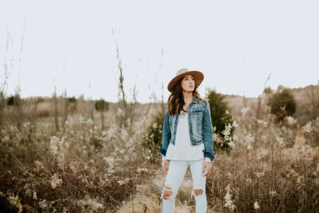 woman in blue denim jacket surrounded by grass during daytime photo