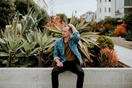 man sitting near plants photo