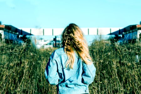 woman wearing blue denim jacket standing on grass field photo