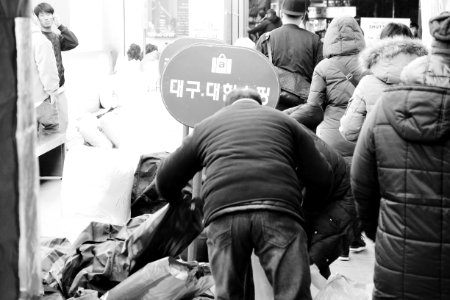 grayscale photo of man pushing cart photo