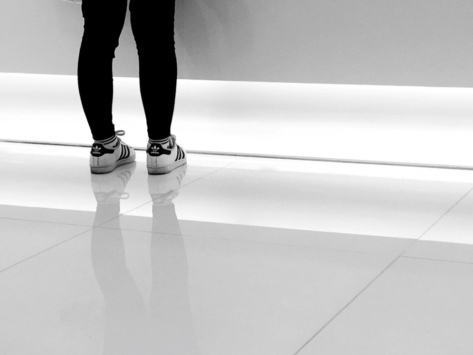 person wearing pair of white-and-black adidas running shoes photo