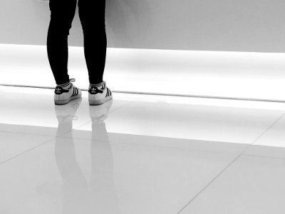 person wearing pair of white-and-black adidas running shoes photo