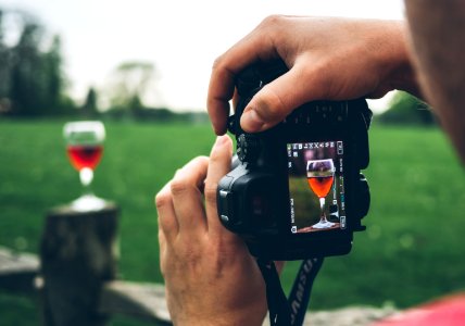 person taking photo of wine goblet