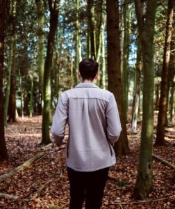 man walking in forest surrounded by trees during daytime photo