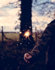 person holding sparkler at daytime photo