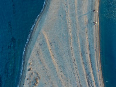 aerial view of white sand surrounded by body of water photo
