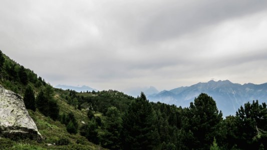 green trees on mountain under cloudy sky during daytime photo