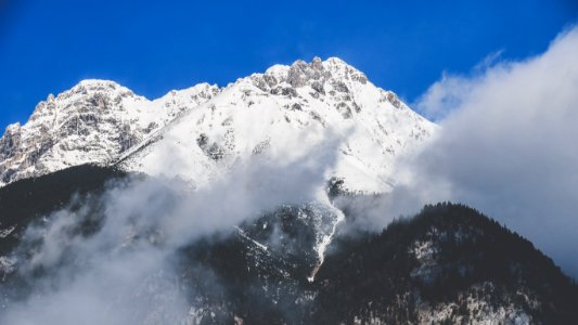 snowy mountain covered by clouds during daytime photo