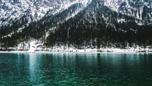 mountain covered with snow near body of water photo