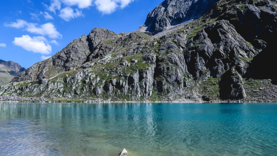 green and gray mountain beside body of water during daytime photo