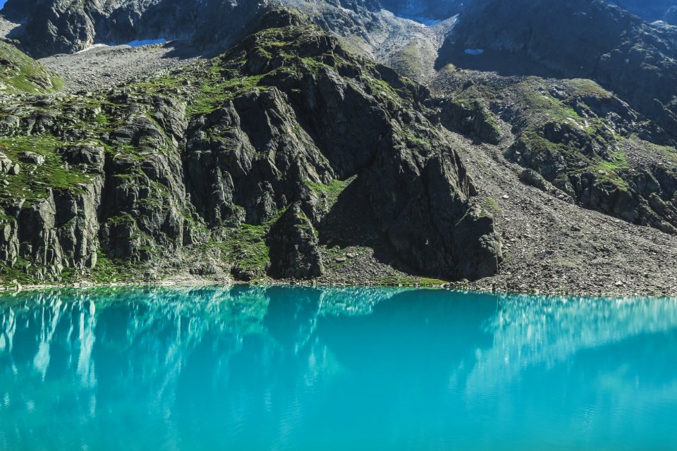 blue lake in the middle of green and gray mountains