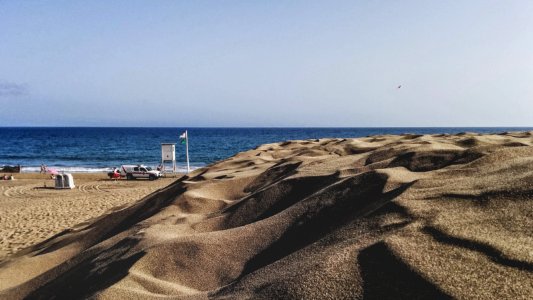 brown sand near body of water during daytime photo