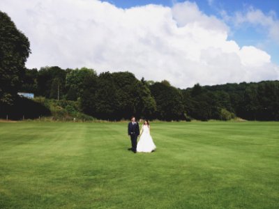 couple standing on grass field photo