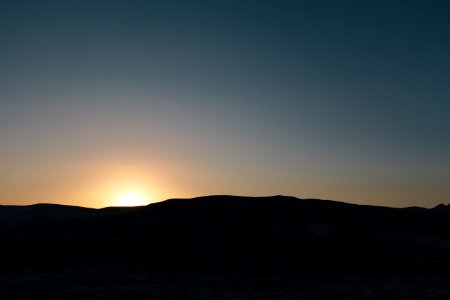 silhouette of mountain during golden sky photo