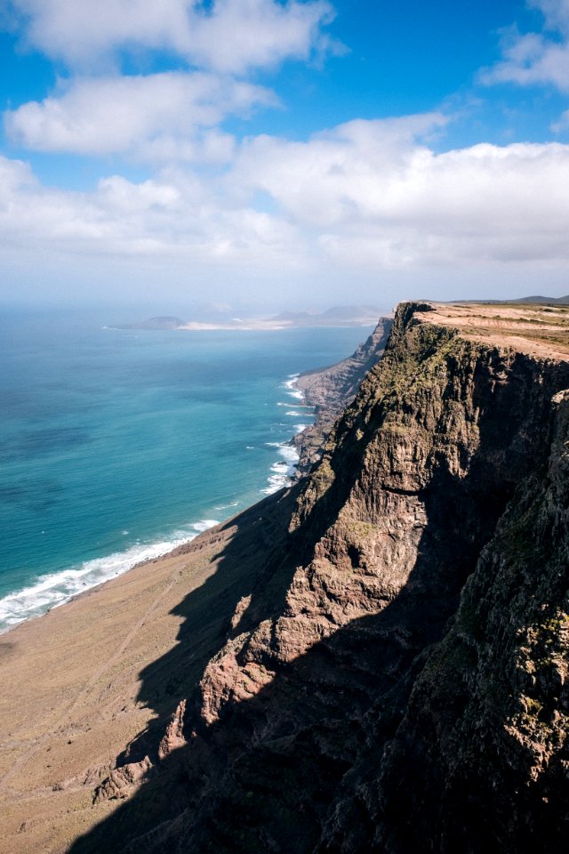 brown cliff beside ocean