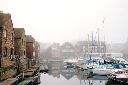 boats on harbour surrounded by fogs during daytime photo