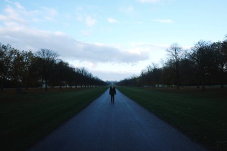 person standing on road under blue sky photo