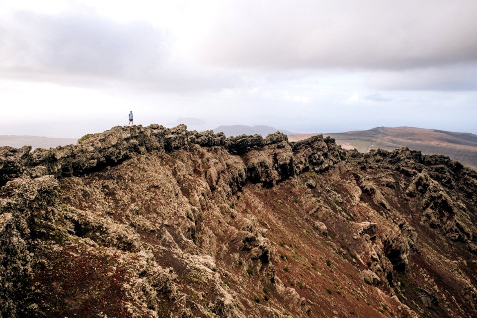person standing on top of mountain during daytime