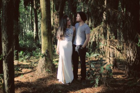 man and woman standing together surrounded by green trees and plants during daytime photo