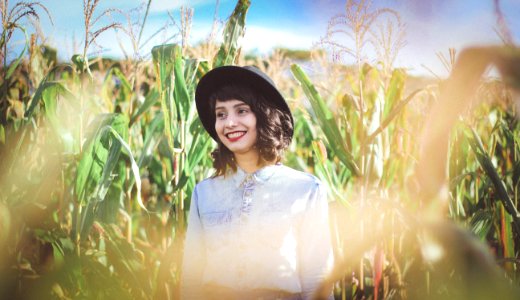 woman in blue denim top standing on cornfield photo