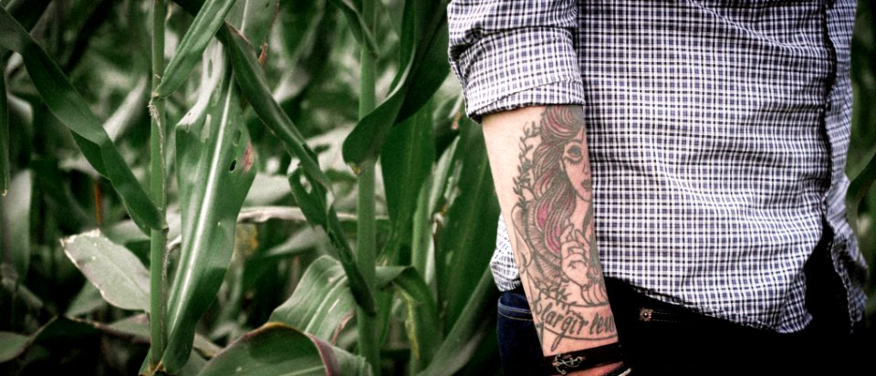 person with arm tattoo walking near green grass photo
