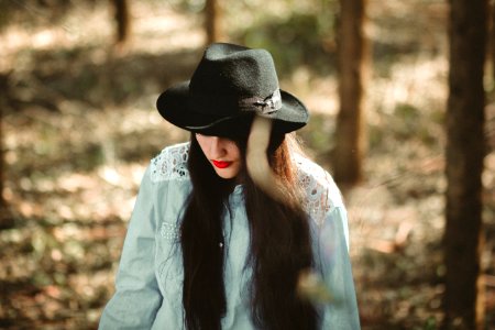 woman wearing blue long-sleeved shirt and black fedora hat photo