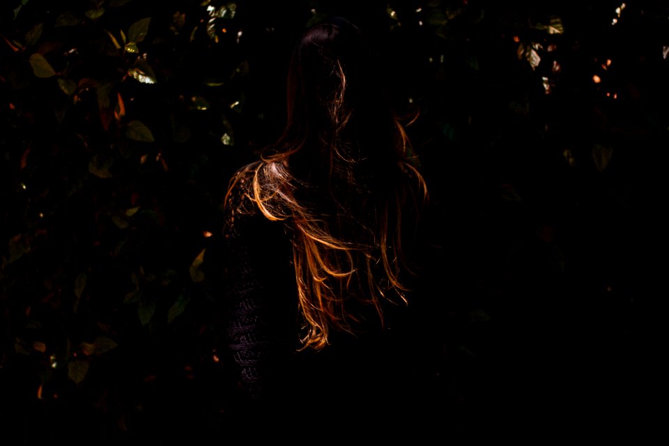 woman standing in front of green leaves
