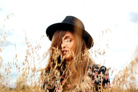 woman wearing black hat near brown grass during daytime photo