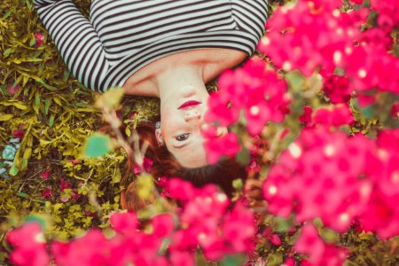 woman in black and white striped top lying on grass photo