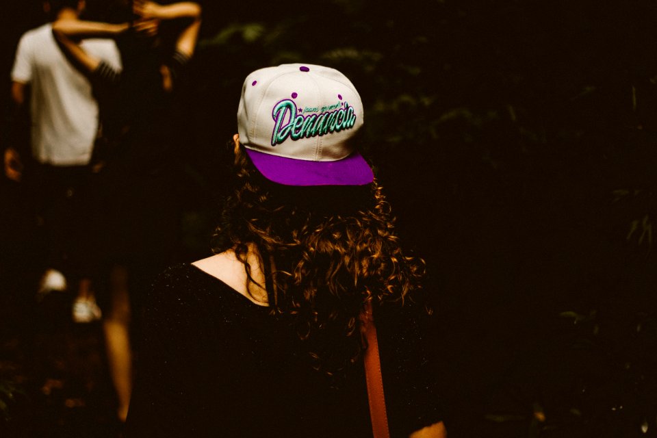 woman wearing white and purple fitted cap