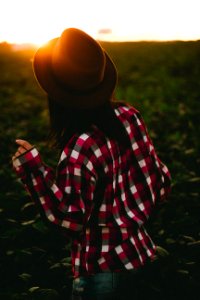 woman wearing hat and checked shirt on green grass photo