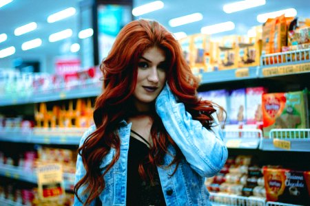 woman in blue denim jacket holding her face in convenient store photo