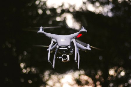 white DJI quadcopter flying selective focus photography photo