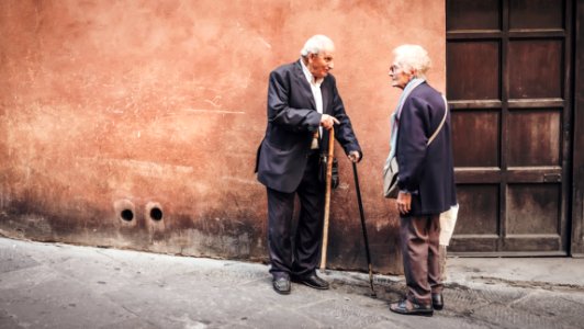 two person talking while standing near wall photo