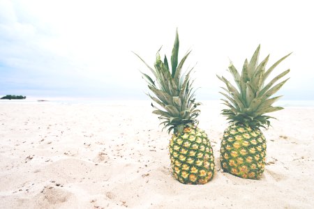 two pineapple fruits on sands photo